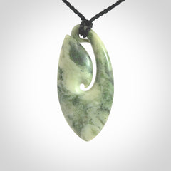 A hand carved medium New Zealand Jade Hook, Matau, necklace. The cord is adjustable