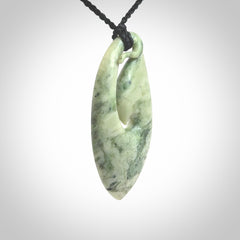 A hand carved medium New Zealand Jade Hook, Matau, necklace. The cord is adjustable