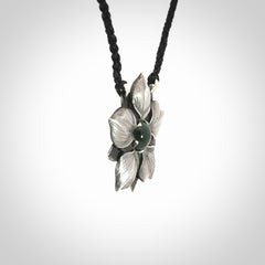 This is a hand carved Sterling Silver Manuka Flower pendant with New Zealand Jade insert. This is a medium sized necklace and is provided with an adjustable black cord.