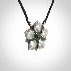 This is a hand carved Sterling Silver Manuka Flower pendant with New Zealand Jade insert. This is a medium sized necklace and is provided with an adjustable black cord.