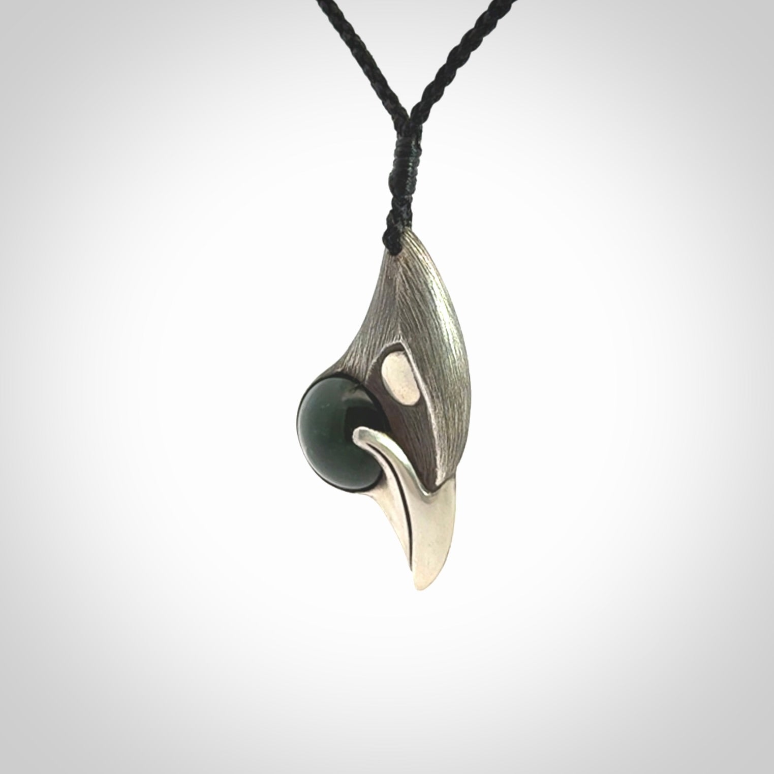This is a hand carved Sterling Silver Saddleback, Kokako, bird pendant with British Columbian Jade insert. This is a medium sized necklace and is provided with an adjustable black cord.