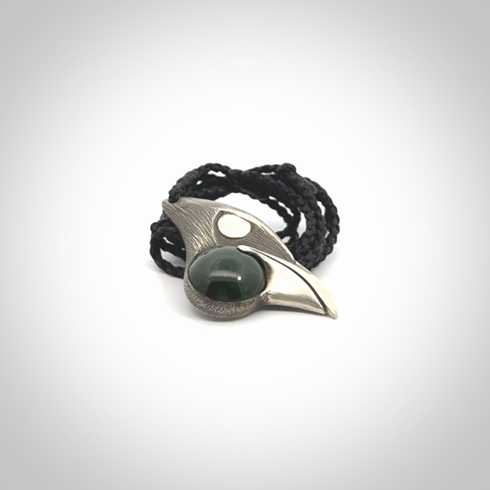 This is a hand carved Sterling Silver Saddleback, Kokako, bird pendant with British Columbian Jade insert. This is a medium sized necklace and is provided with an adjustable black cord.