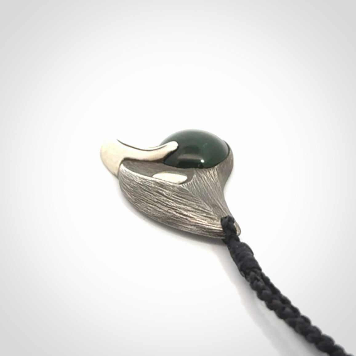 This is a hand carved Sterling Silver Saddleback, Kokako, bird pendant with British Columbian Jade insert. This is a medium sized necklace and is provided with an adjustable black cord.