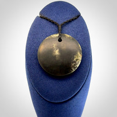 A Hand Carved New Zealand jade disc pendant