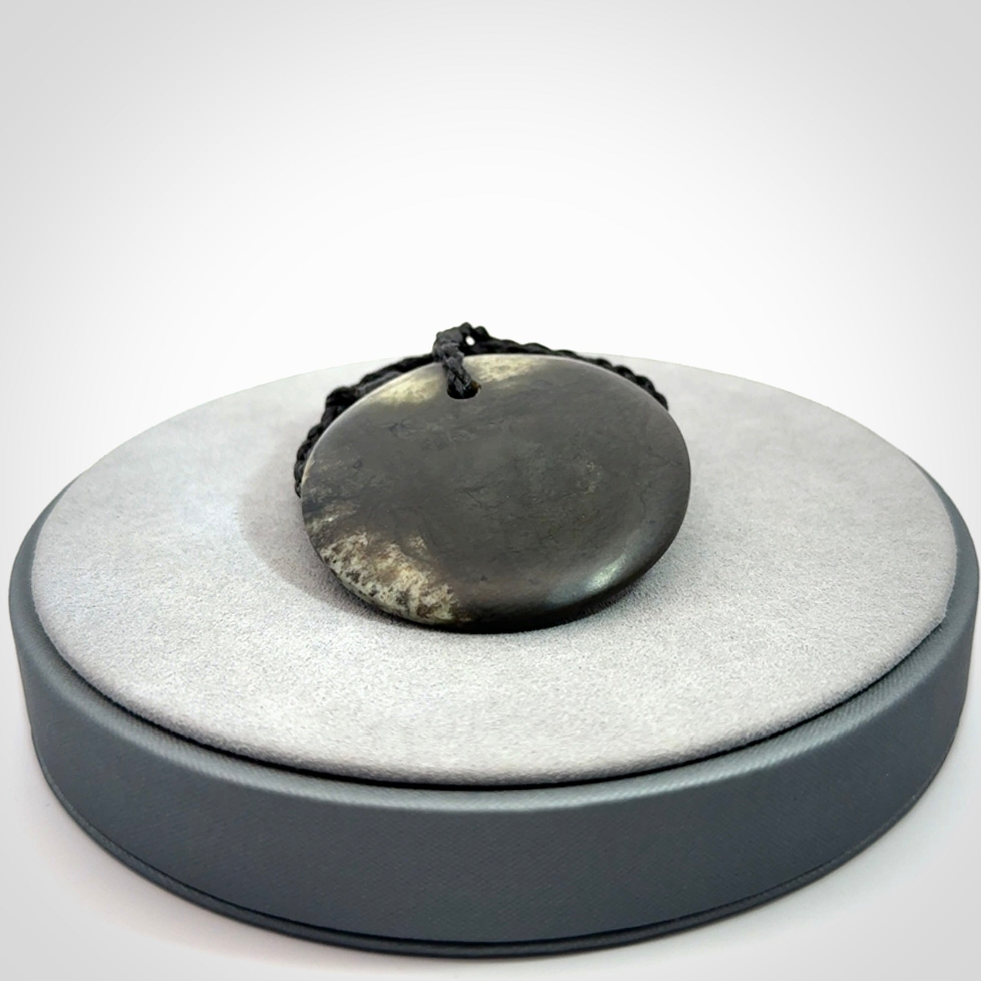 A Hand Carved New Zealand jade disc pendant