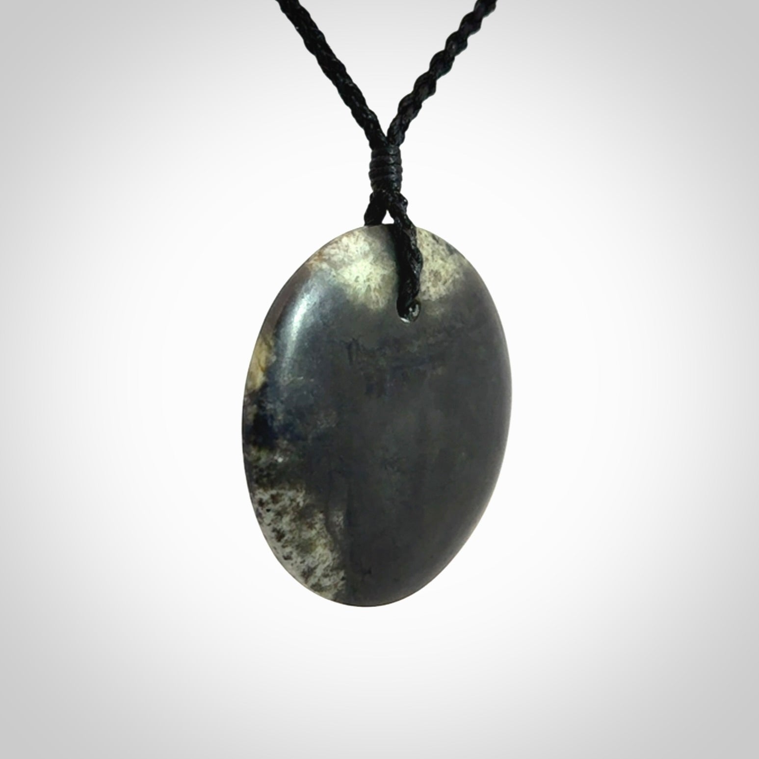A Hand Carved New Zealand jade disc pendant