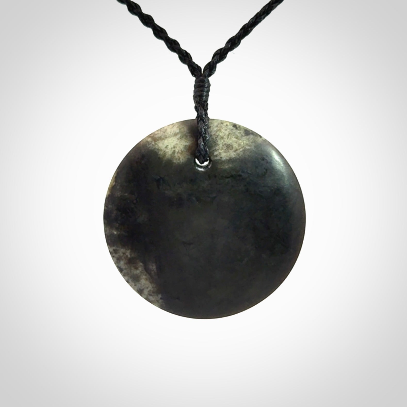 A Hand Carved New Zealand jade disc pendant