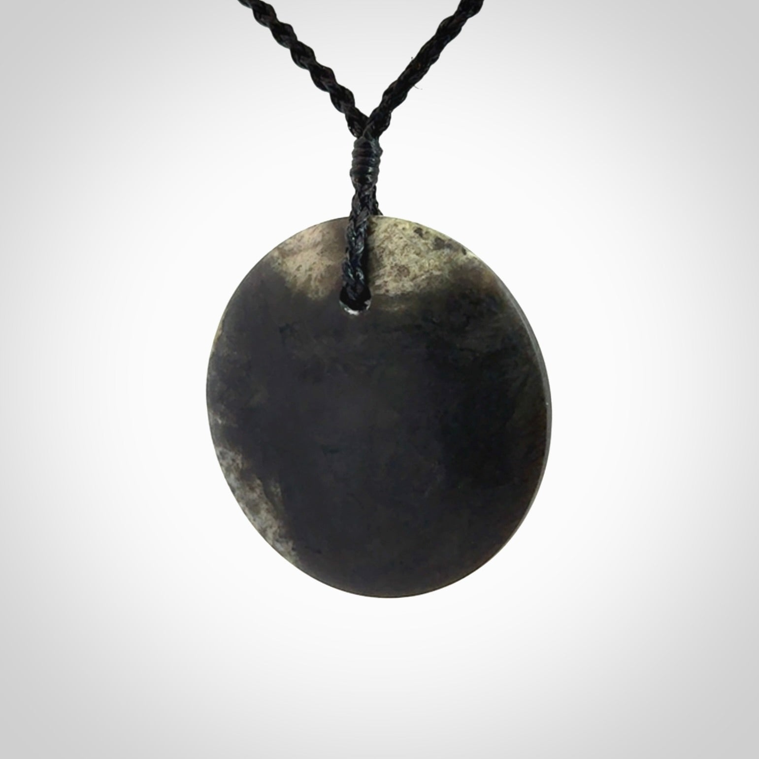 A Hand Carved New Zealand jade disc pendant