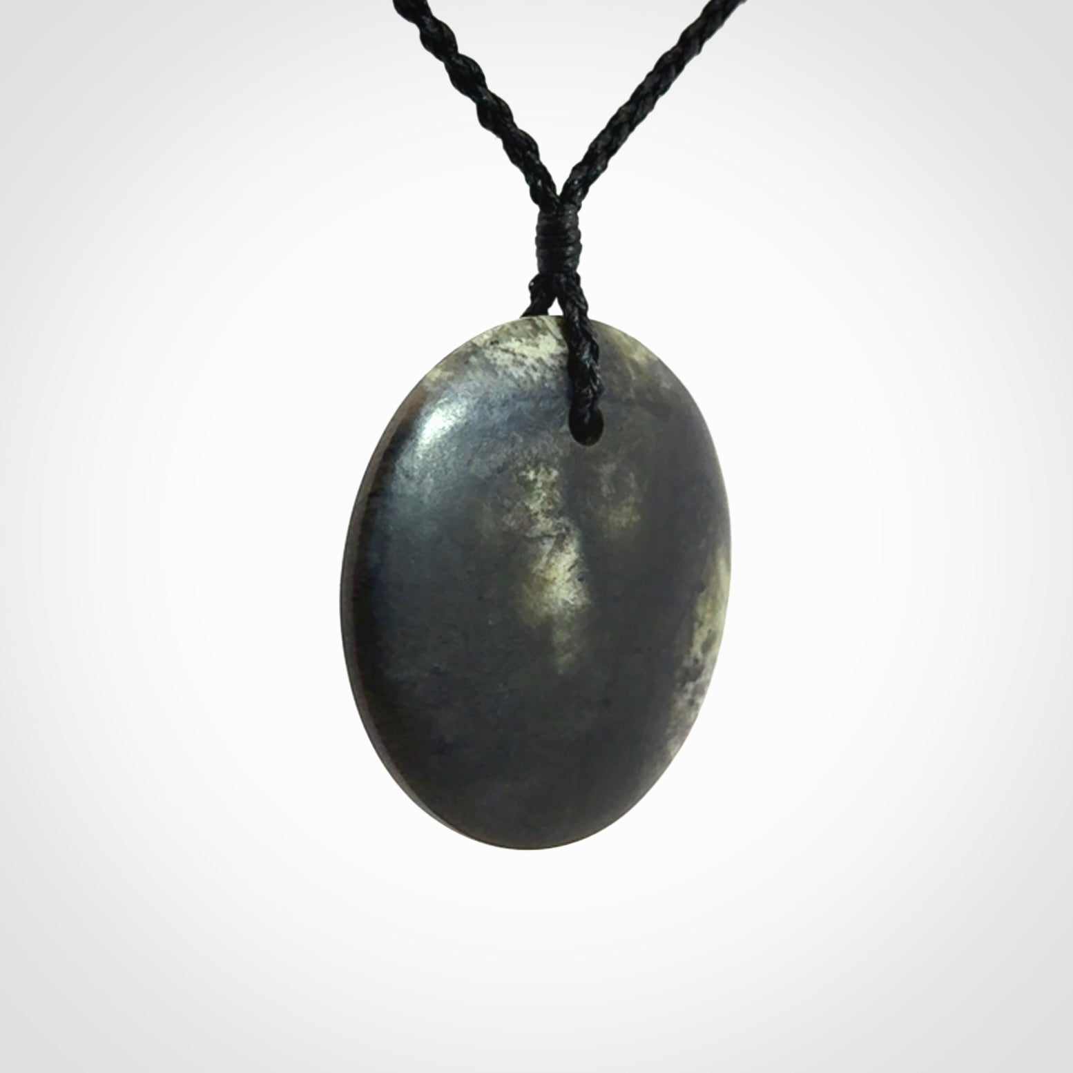 A Hand Carved New Zealand jade disc pendant