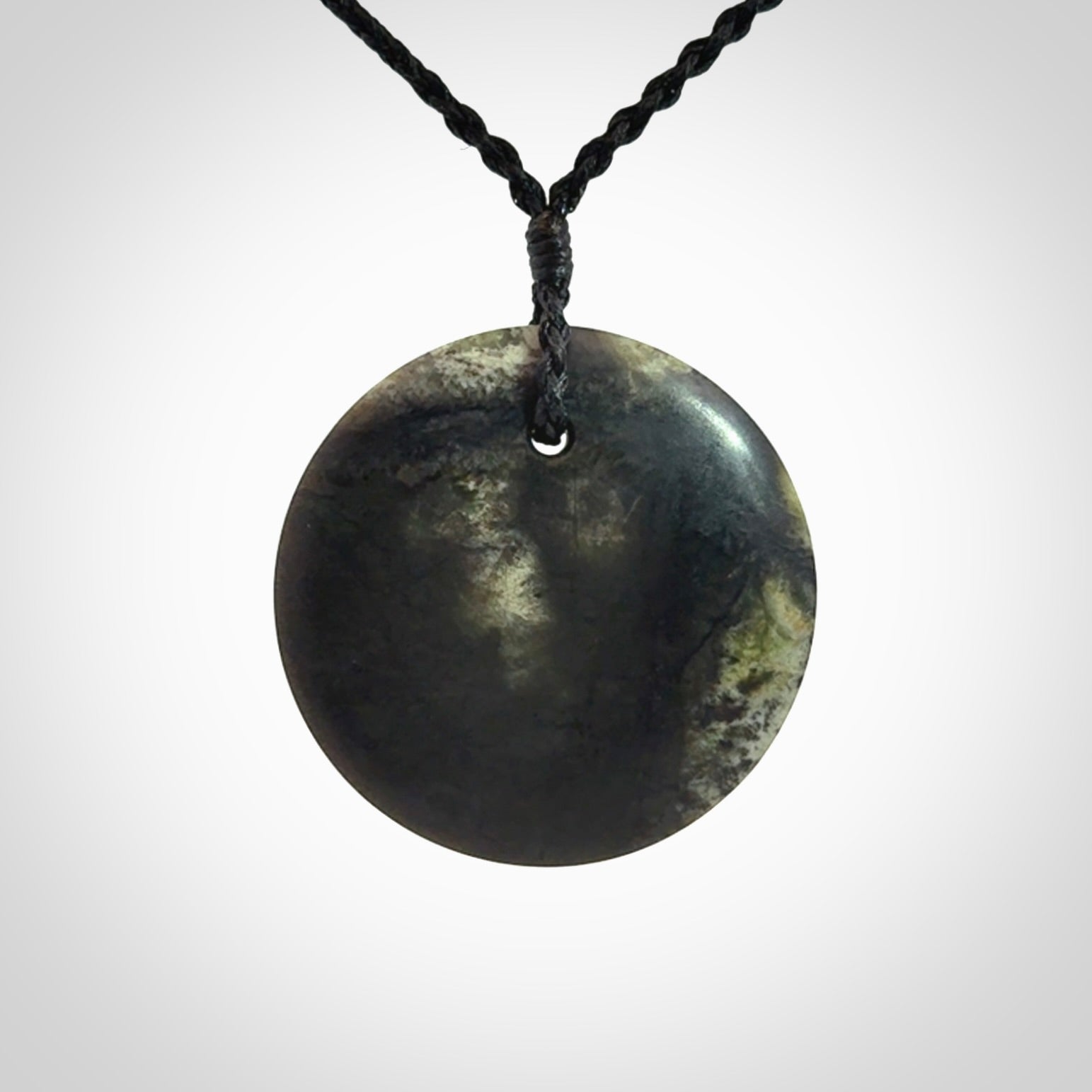 A Hand Carved New Zealand jade disc pendant