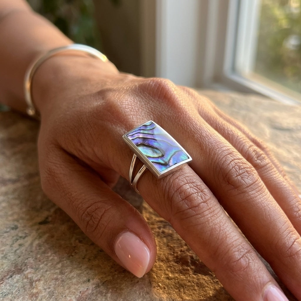 Hand wearing paua shell ring