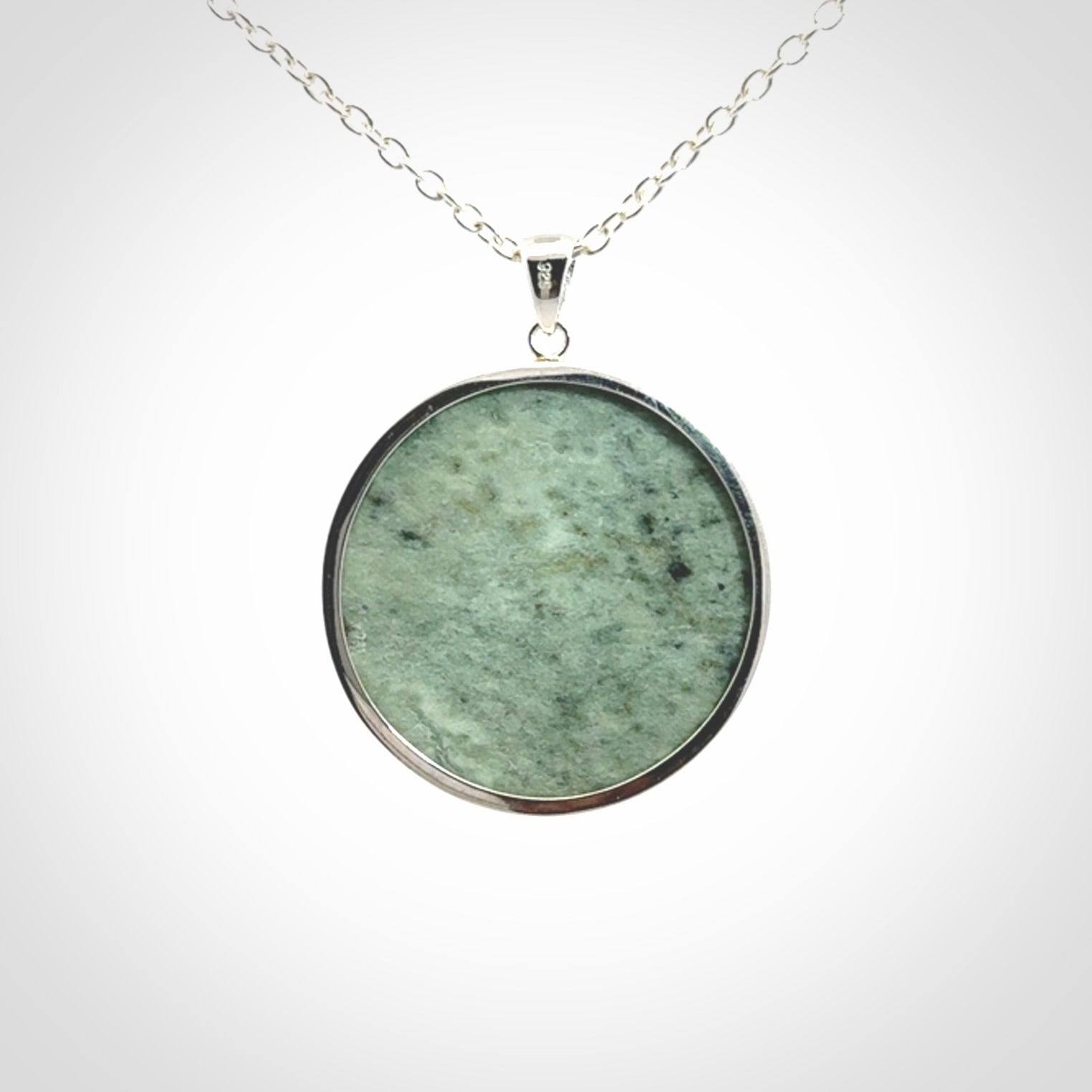 Hand made New Zealand Jade moon face necklace with Sterling Silver. Made by NZ Pacific and sale online only. Delivered with sterling silver chain and packaged in a woven kete pouch.