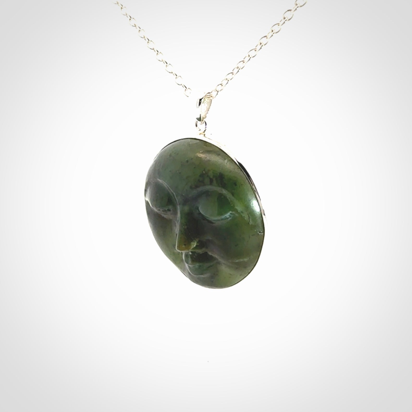 Hand made New Zealand Jade moon face necklace with Sterling Silver. Made by NZ Pacific and sale online only. Delivered with sterling silver chain and packaged in a woven kete pouch.