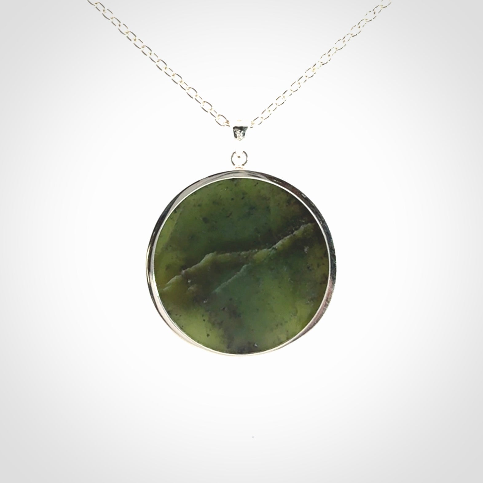 Hand made New Zealand Jade moon face necklace with Sterling Silver. Made by NZ Pacific and sale online only. Delivered with sterling silver chain and packaged in a woven kete pouch.