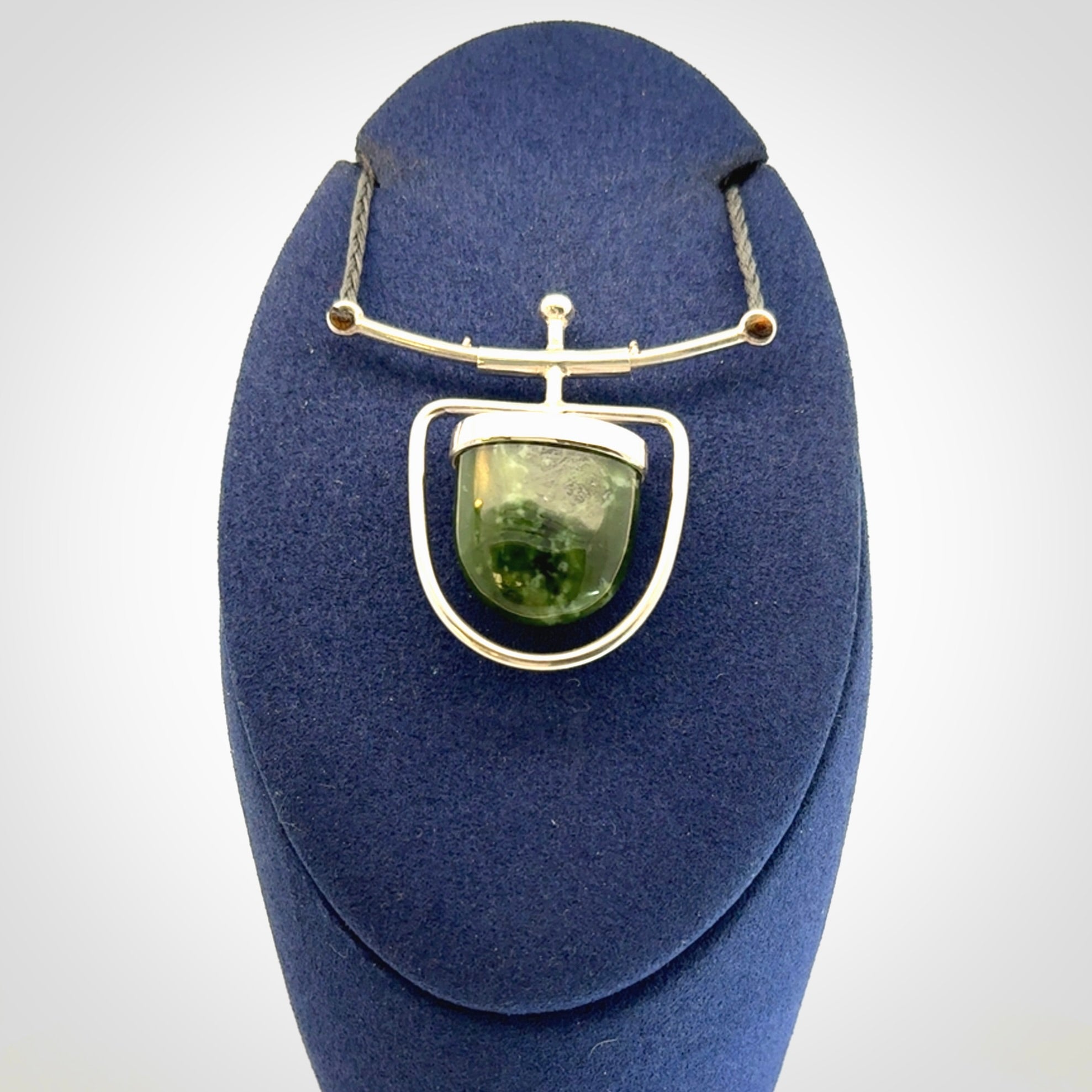 Hand crafted contemporary green jade and sterling silver drop necklace. This necklace is provided with a adjustable cord. Contemporary green jade drop necklace with sterling silver.
