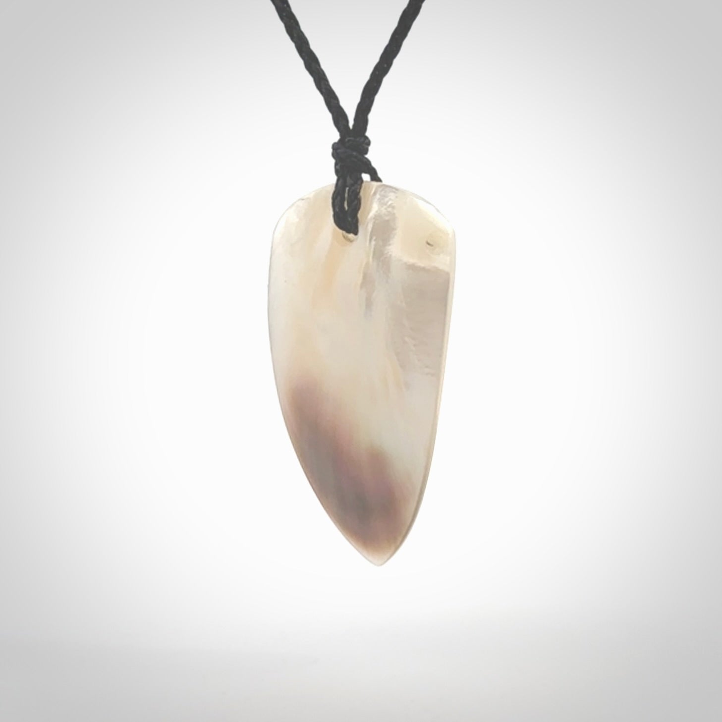 This photo shows a medium sized drop pendant hand carved from Mother of Pearl.This is a one only necklace for those who appreciate art to wear. It is provided with a cord in black that is a adjustable in length. We ship this piece worldwide and shipping is included in the price.