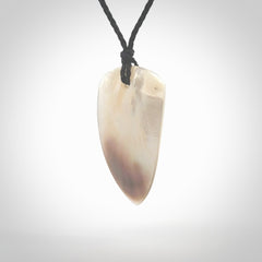 This photo shows a medium sized drop pendant hand carved from Mother of Pearl.This is a one only necklace for those who appreciate art to wear. It is provided with a cord in black that is a adjustable in length. We ship this piece worldwide and shipping is included in the price.