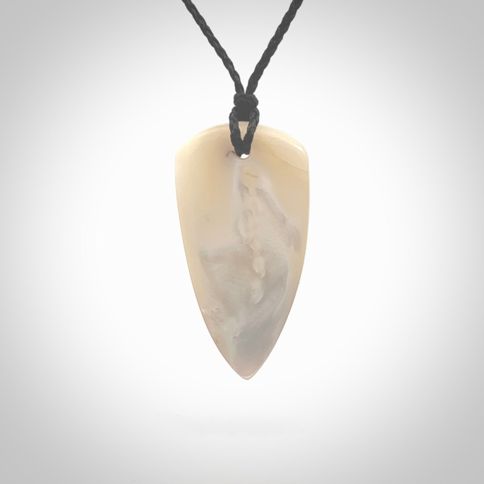 This photo shows a medium sized drop pendant hand carved from Mother of Pearl.This is a one only necklace for those who appreciate art to wear. It is provided with a cord in black that is a adjustable in length. We ship this piece worldwide and shipping is included in the price.