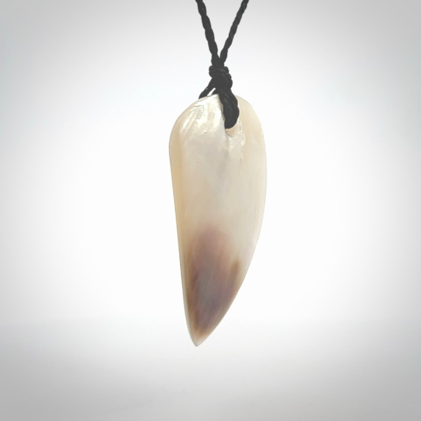 This photo shows a medium sized drop pendant hand carved from Mother of Pearl.This is a one only necklace for those who appreciate art to wear. It is provided with a cord in black that is a adjustable in length. We ship this piece worldwide and shipping is included in the price.