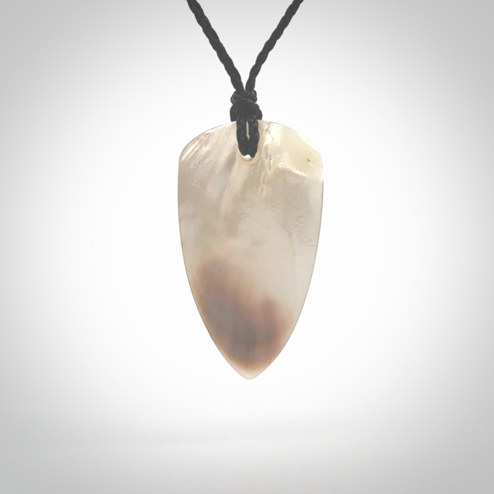 This photo shows a medium sized drop pendant hand carved from Mother of Pearl.This is a one only necklace for those who appreciate art to wear. It is provided with a cord in black that is a adjustable in length. We ship this piece worldwide and shipping is included in the price.
