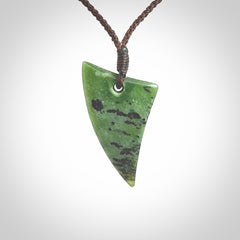 This is a lovely New Zealand Jade, pounamu niho drop pendant. Hand carved for us by Ric Moor. It is bound with an adjustable brown coloured cord which is length adjustable. Free worldwide shipping.
