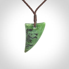 This is a lovely New Zealand Jade, pounamu niho drop pendant. Hand carved for us by Ric Moor. It is bound with an adjustable brown coloured cord which is length adjustable. Free worldwide shipping.