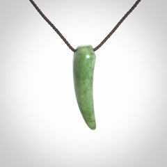 This is a lovely New Zealand Jade, pounamu niho drop pendant. Hand carved for us by Ric Moor. It is bound with an adjustable brown coloured cord which is length adjustable. Free worldwide shipping.