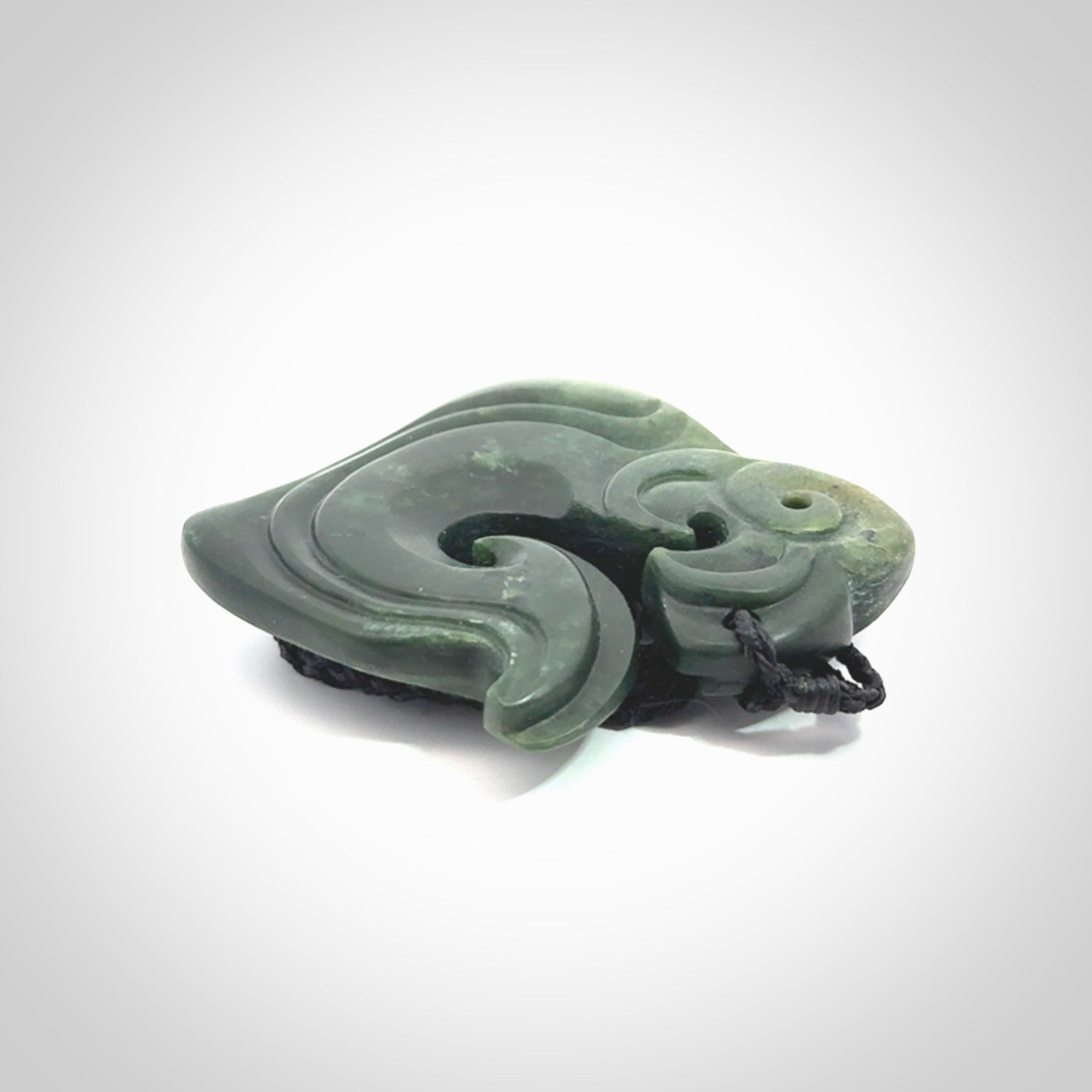 A beautiful hand carved, New Zealand Jade Matau, hook pendant.
