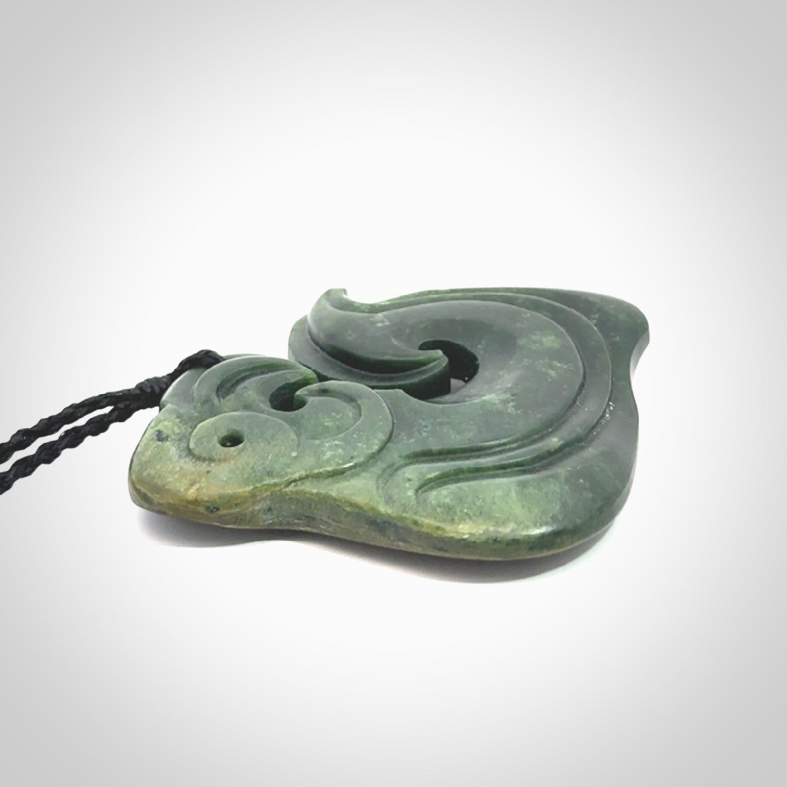A beautiful hand carved, New Zealand Jade Matau, hook pendant.