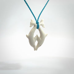 Hand carved natural double dolphin bone pendant. Hand made bone dolphin necklace, delivered with Express Courier. Hand crafted bone double dolphin pendant. Provided with an adjustable paradise blue cord.