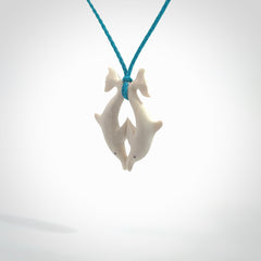 Hand carved natural double dolphin bone pendant. Hand made bone dolphin necklace, delivered with Express Courier. Hand crafted bone double dolphin pendant. Provided with an adjustable paradise blue cord.