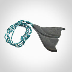 Hand carved New Zealand Argillite Stone whale tail pendant by Rueben Tipene. Hand made art to wear for lovers of the ocean. Delivered with express courier and delivered to you on an adjustable cord.
