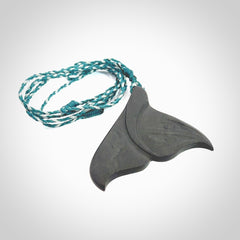 Hand carved New Zealand Argillite Stone whale tail pendant by Rueben Tipene. Hand made art to wear for lovers of the ocean. Delivered with express courier and delivered to you on an adjustable cord.