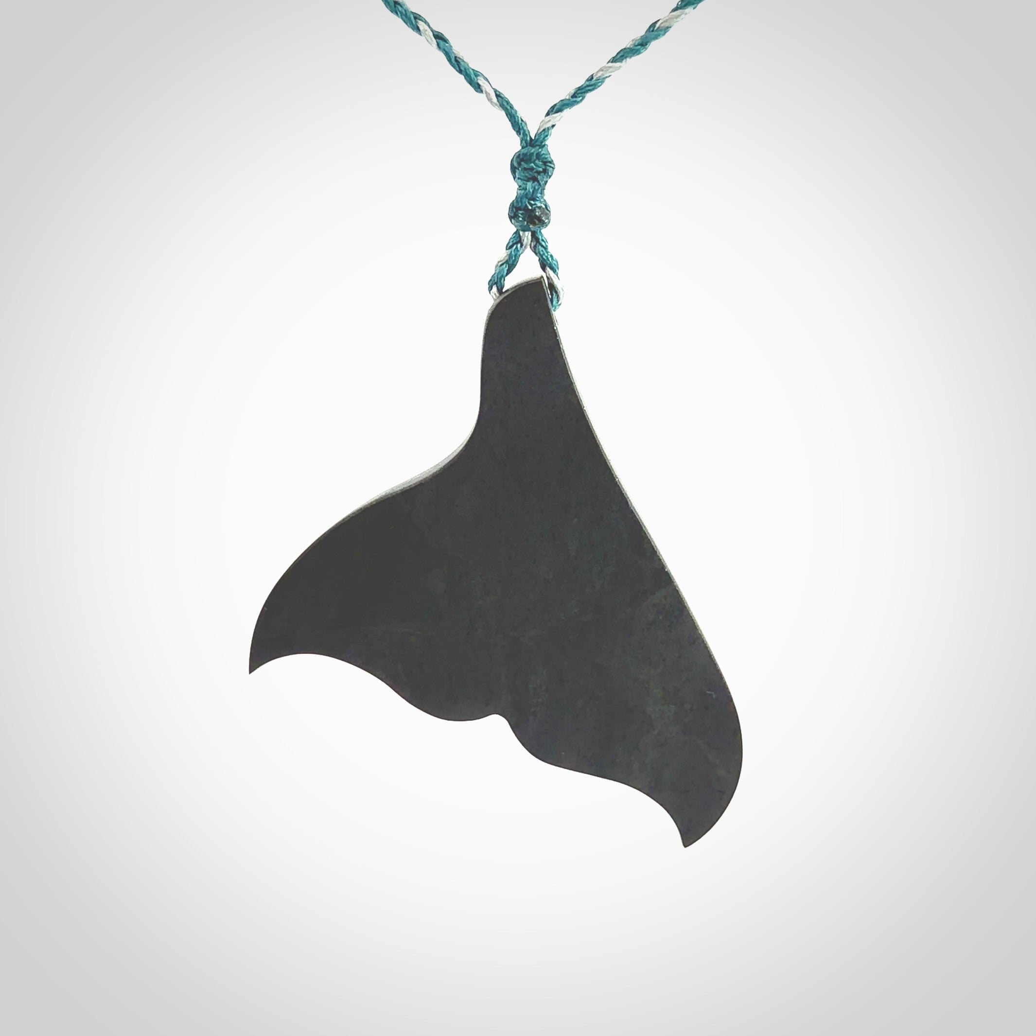 Hand carved New Zealand Argillite Stone whale tail pendant by Rueben Tipene. Hand made art to wear for lovers of the ocean. Delivered with express courier and delivered to you on an adjustable cord.