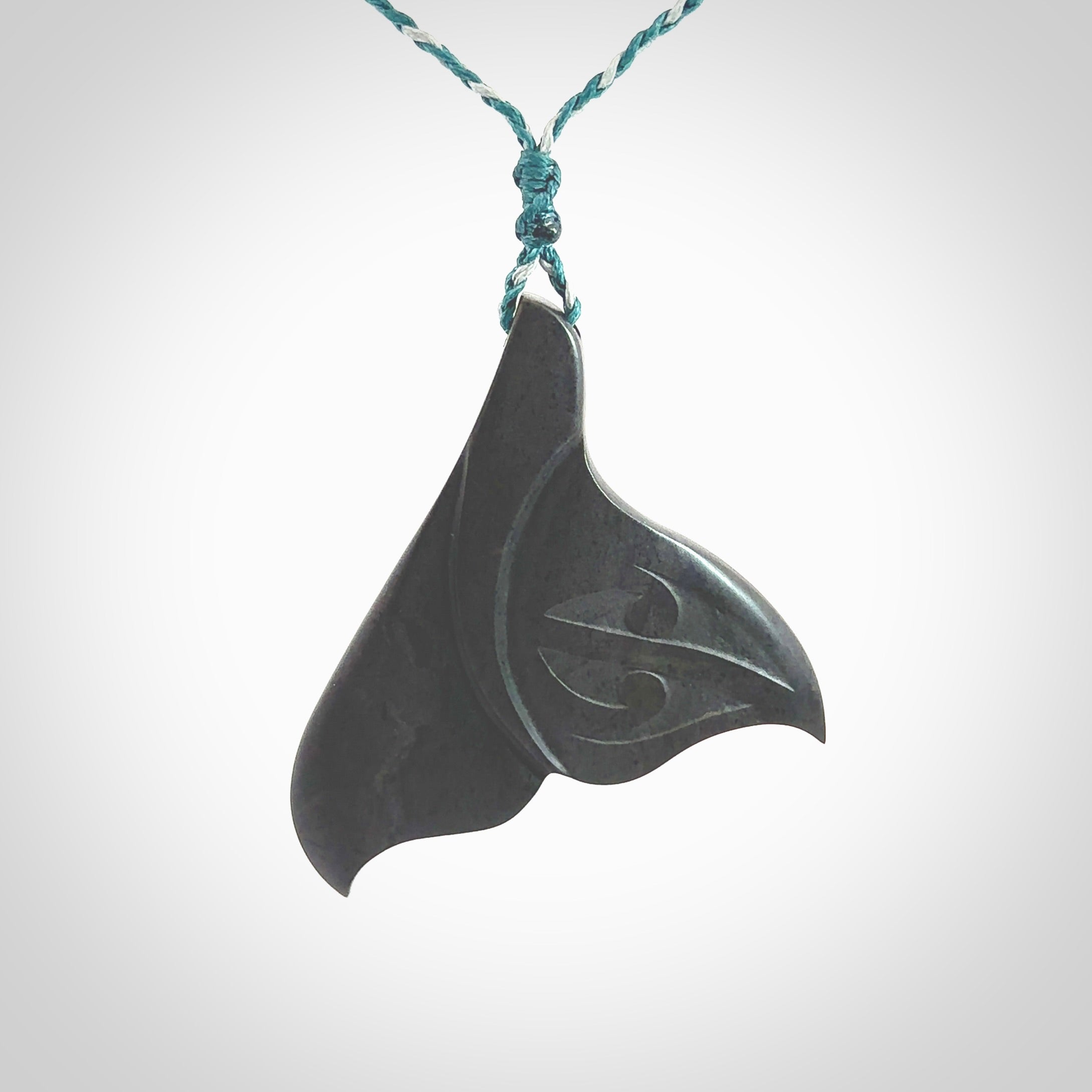 Hand carved New Zealand Argillite Stone whale tail pendant by Rueben Tipene. Hand made art to wear for lovers of the ocean. Delivered with express courier and delivered to you on an adjustable cord.