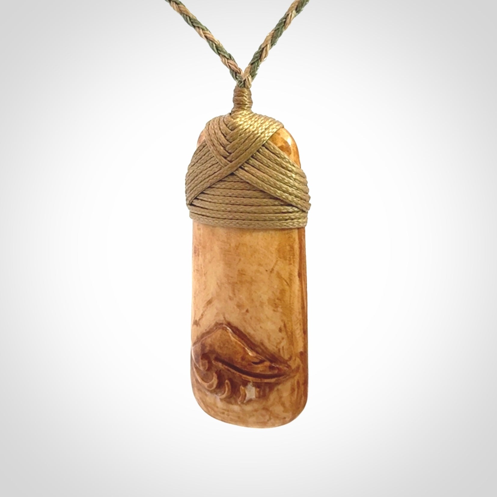 A hand carved bone toki pendant with NZ Pacific logo engraving. These have been stained with our home made tea dye. Unique hand made jewellery from New Zealand Pacific.