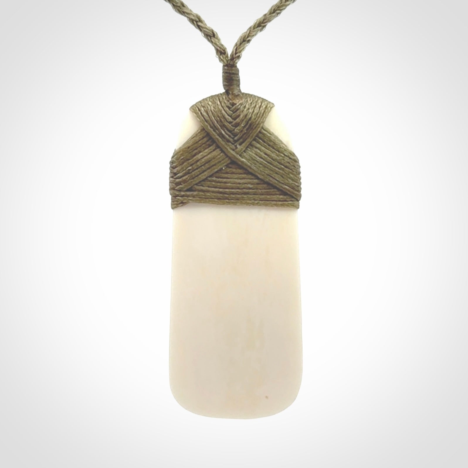 A hand carved bone toki with NZ Pacific logo engraving. Unique hand made jewellery from New Zealand Pacific.