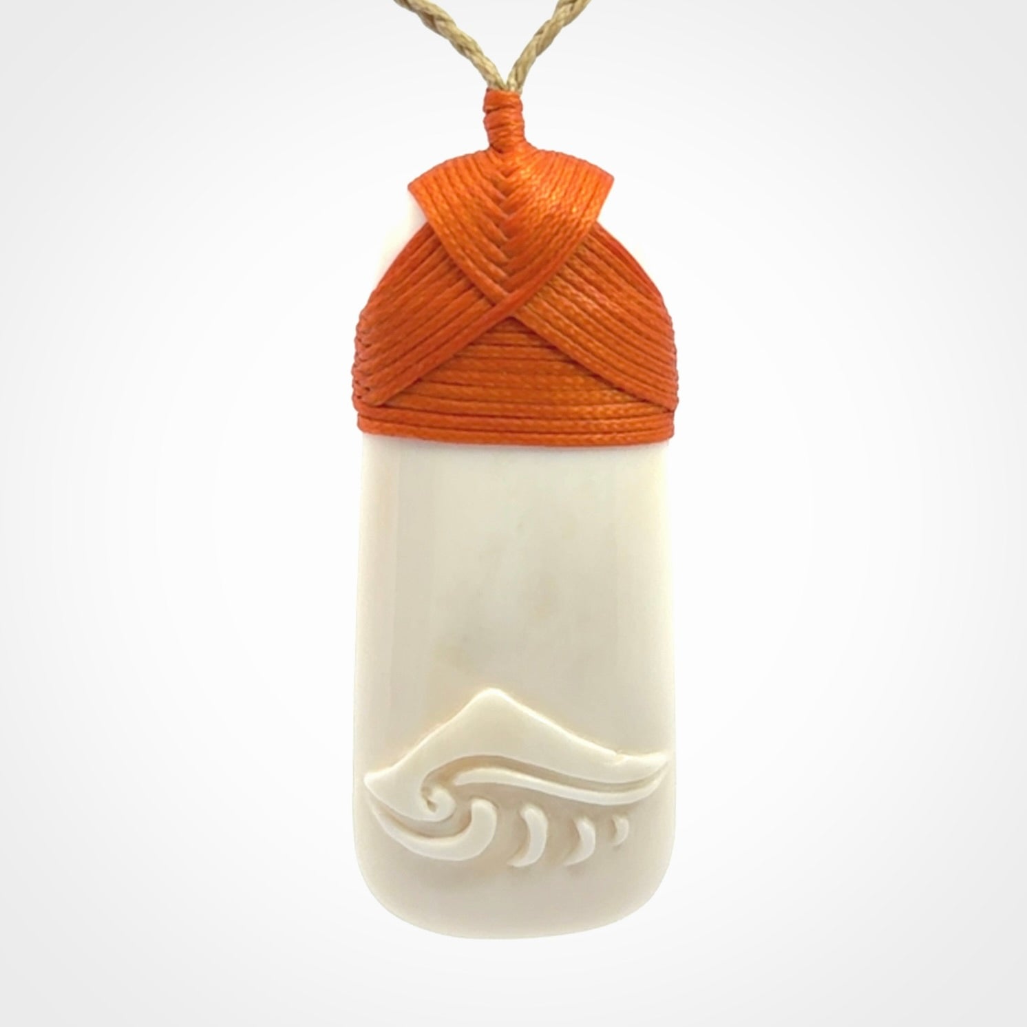 A hand carved bone toki with NZ Pacific logo engraving. Unique hand made jewellery from New Zealand Pacific.
