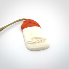 A hand carved bone toki with NZ Pacific logo engraving. Unique hand made jewellery from New Zealand Pacific.