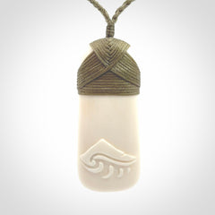 A hand carved bone toki with NZ Pacific logo engraving. Unique hand made jewellery from New Zealand Pacific.