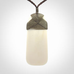A hand carved bone toki with NZ Pacific logo engraving. Unique hand made jewellery from New Zealand Pacific.