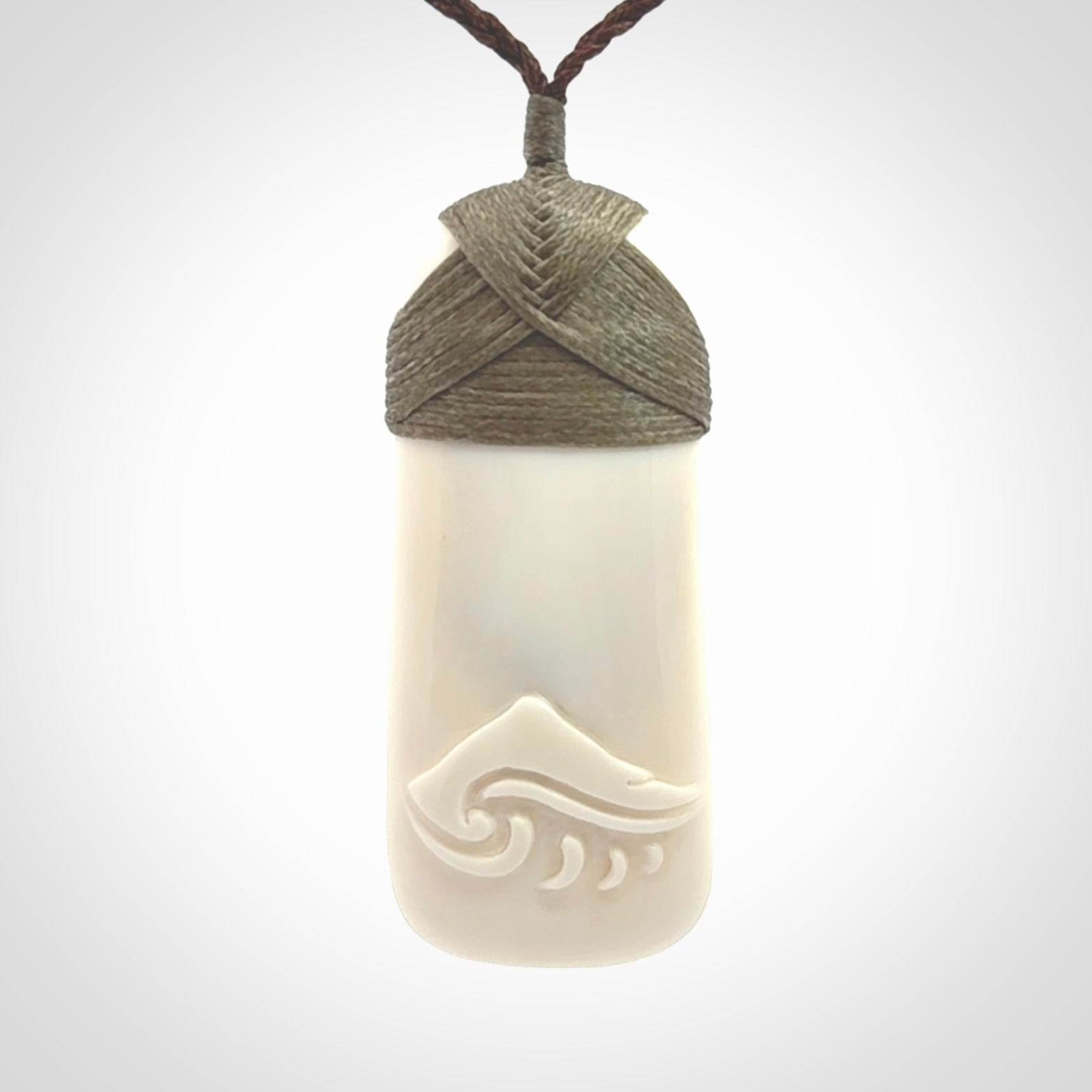A hand carved bone toki with NZ Pacific logo engraving. Unique hand made jewellery from New Zealand Pacific.