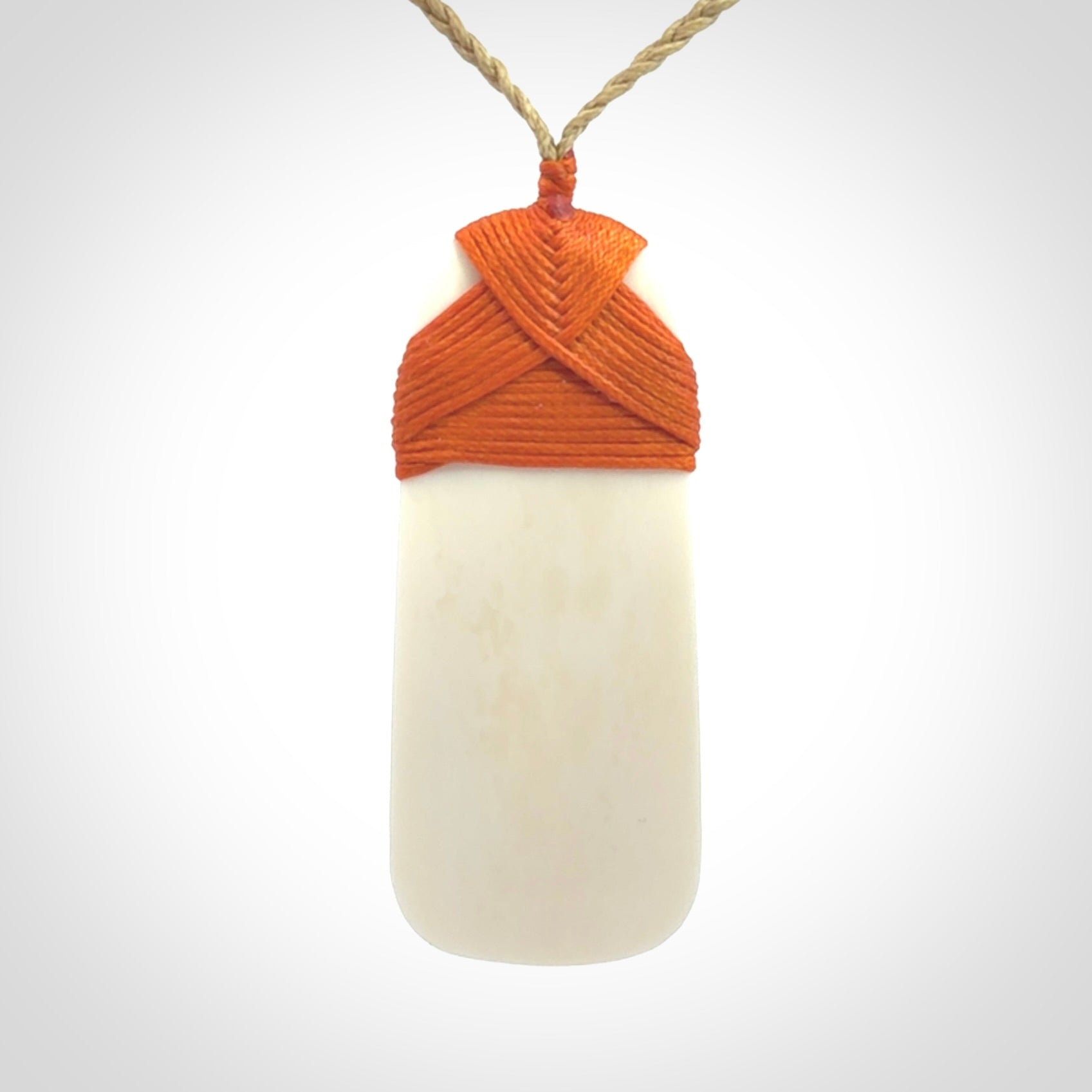 A hand carved bone toki with NZ Pacific logo engraving. Unique hand made jewellery from New Zealand Pacific.