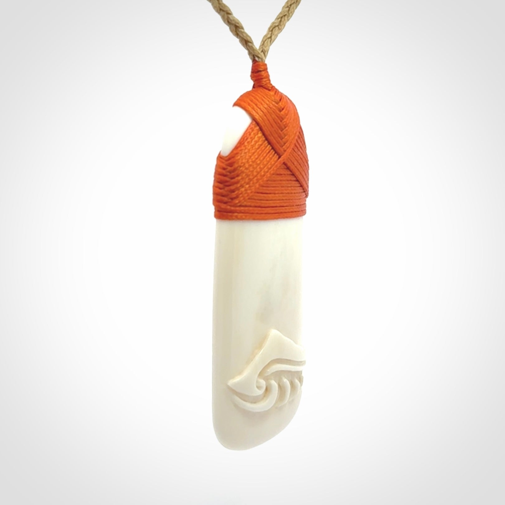 A hand carved bone toki with NZ Pacific logo engraving. Unique hand made jewellery from New Zealand Pacific.