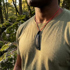 man wearing a black jade feather pendant