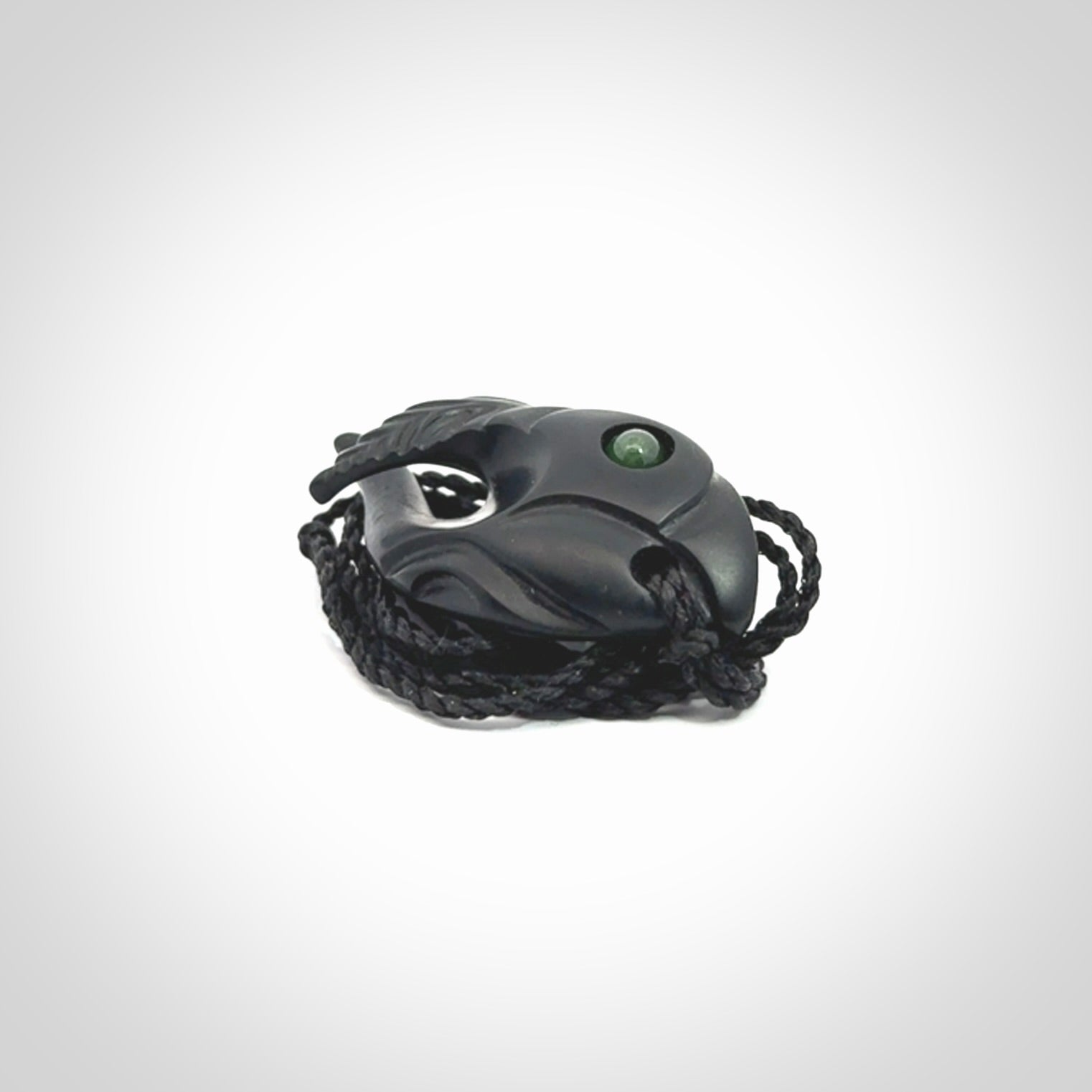 This is a hand carved Black Jade bird head pendant with New Zealand Jade insert. This is a smaller sized necklace and is provided with an adjustable black cord.