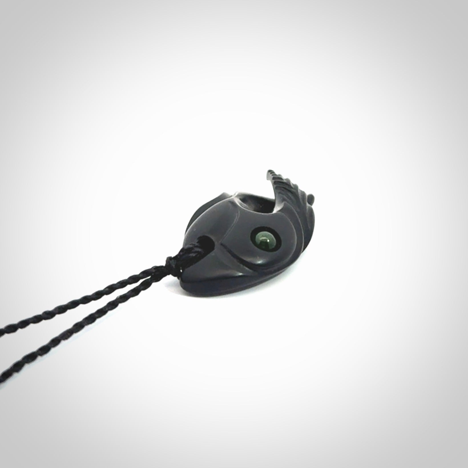 This is a hand carved Black Jade bird head pendant with New Zealand Jade insert. This is a smaller sized necklace and is provided with an adjustable black cord.
