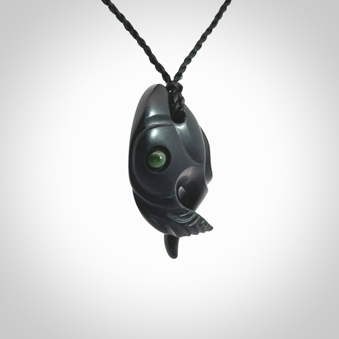 This is a hand carved Black Jade bird head pendant with New Zealand Jade insert. This is a smaller sized necklace and is provided with an adjustable black cord.