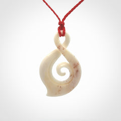 Hand carved twist with koru. Made from natural bone by NZ Pacific. Delivered with an adjustable cord.