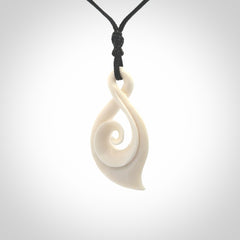 Hand carved twist with koru. Made from natural bone by NZ Pacific. Delivered with an adjustable cord.